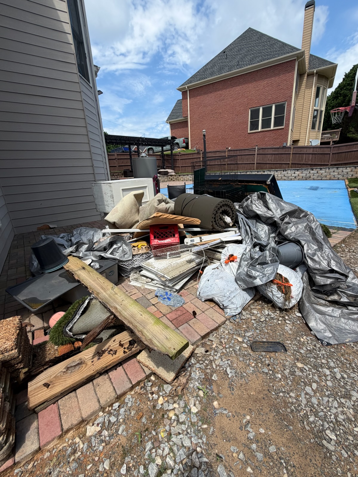 Real Gwinnett County backyard with junk staged for pickup